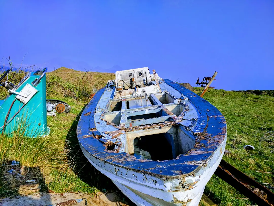 An old blue-and-white rowing boat pulled up on the grass on Eigg