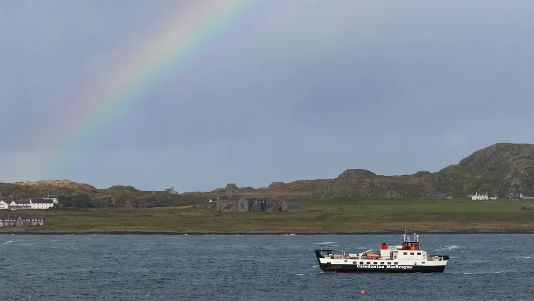 A ferry crossing the Sound of Iona under a rainbow