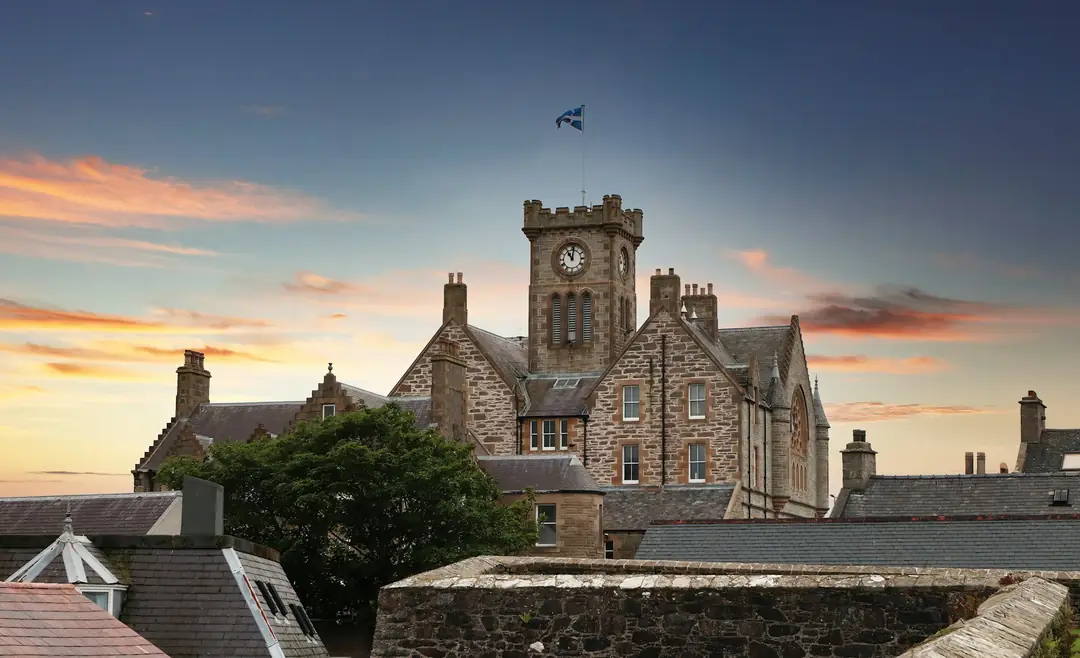 Lerwick Town Hall's clock tower above the rooftops at sunset